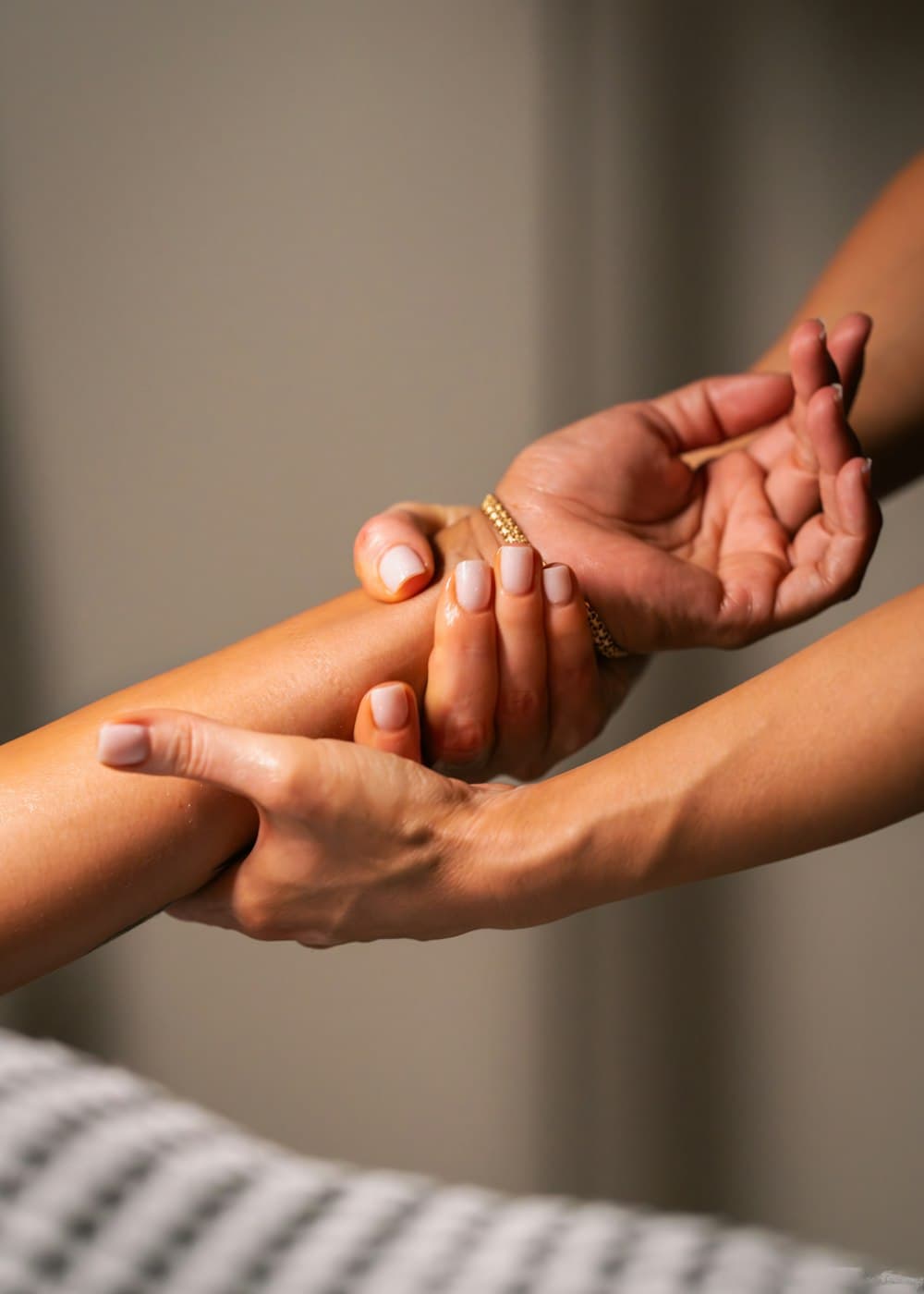 Mãos massageando o antebraço de uma cliente