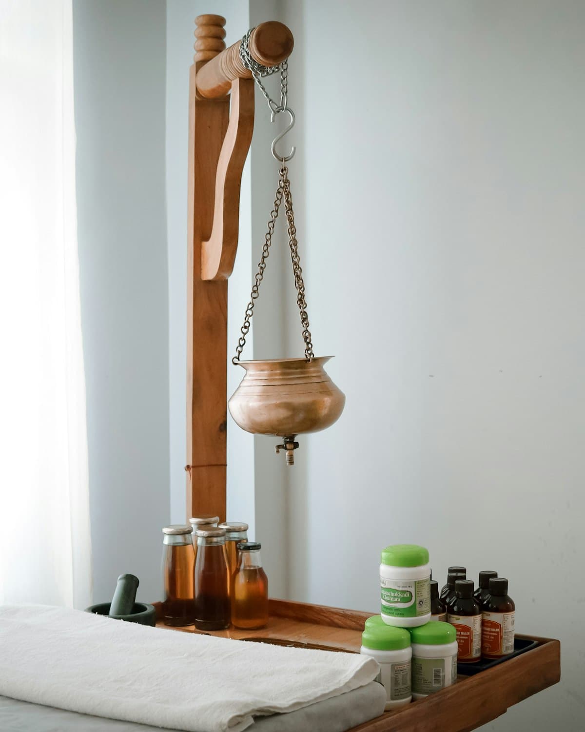 Sala de atendimento com maca e frascos de óleos